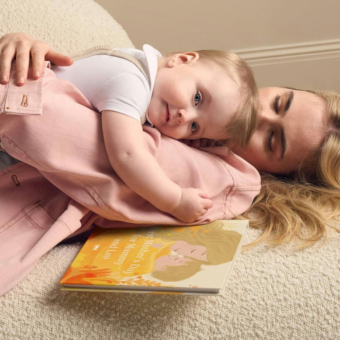 mum and baby lying on floor with book