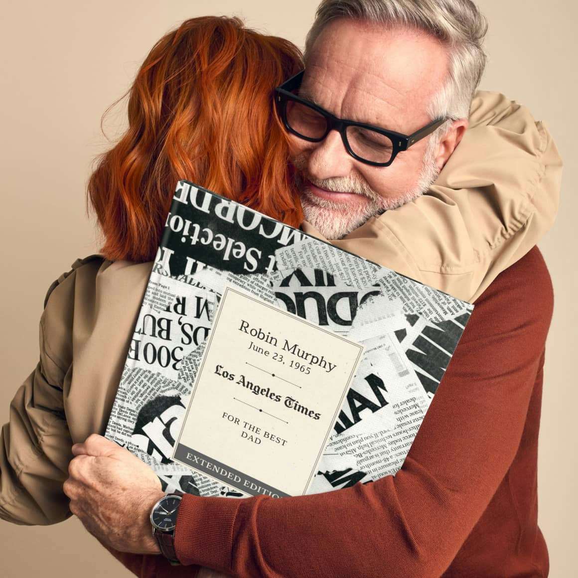 father hugging adult daughter holiding a personalised book