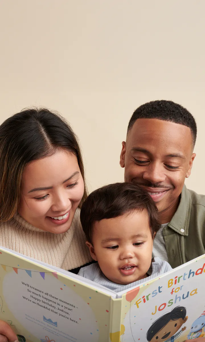 Parents and child reading a personalized "First Birthday for You" book