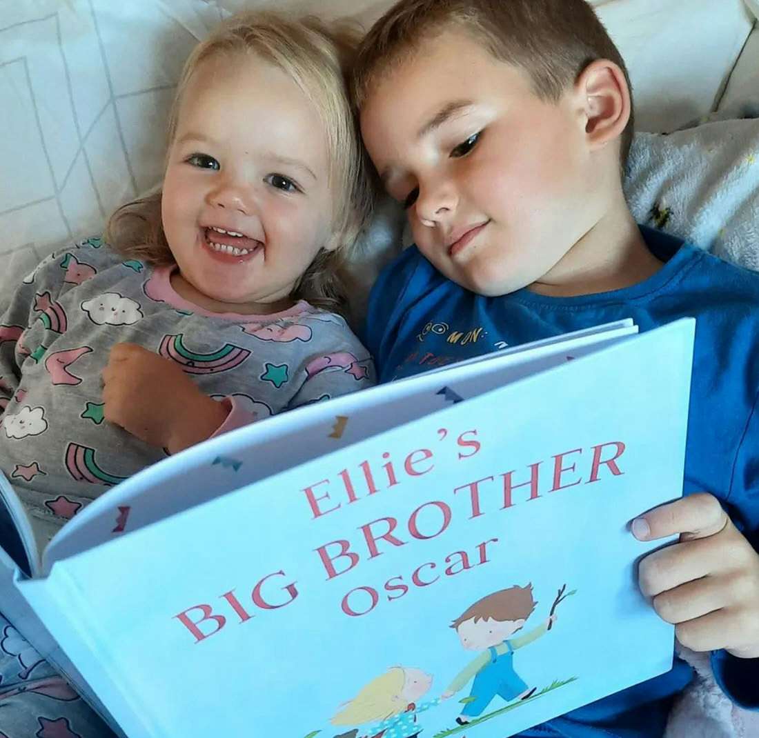 Siblings holding a personalized book