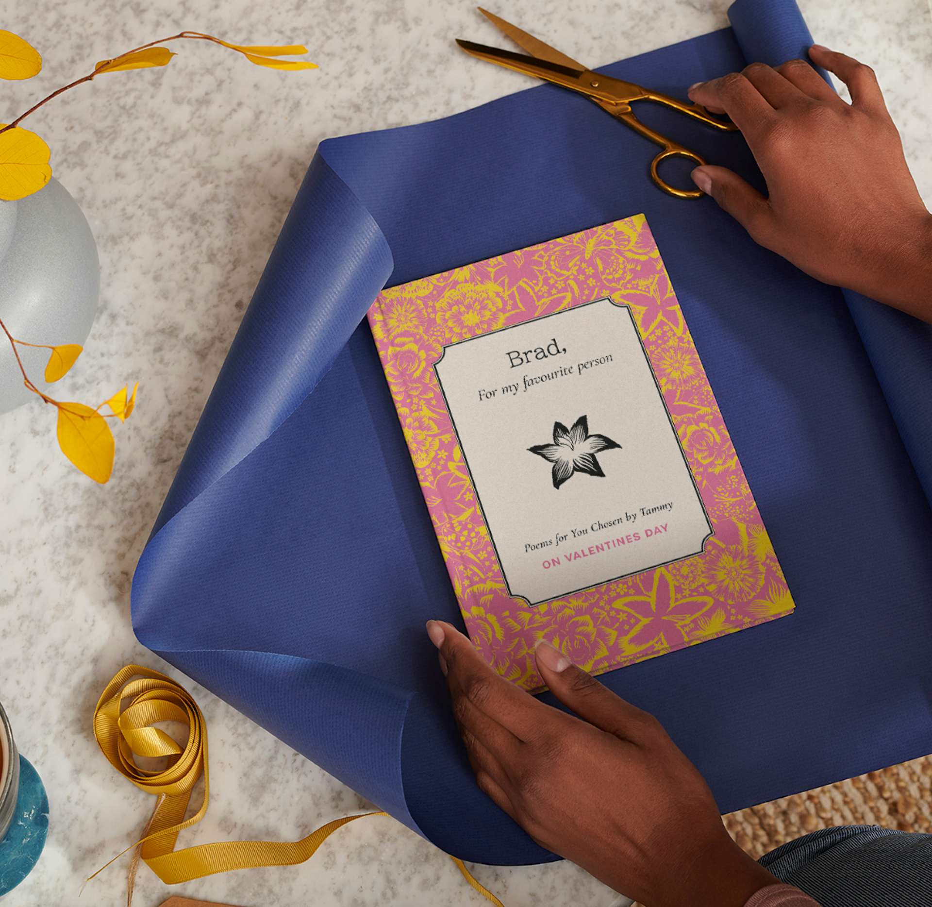 Hands wrapping a personalised book in gift wrap