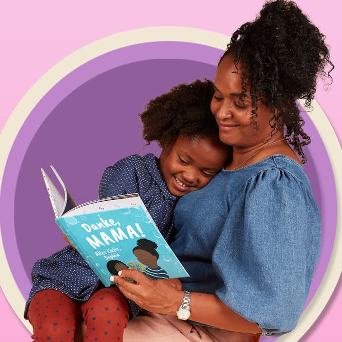 Erwachsener und Kind lesen gemeinsam Danke Mama