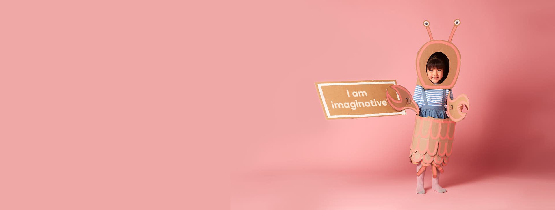 3-6 year old child holding sign "I am imaginative"