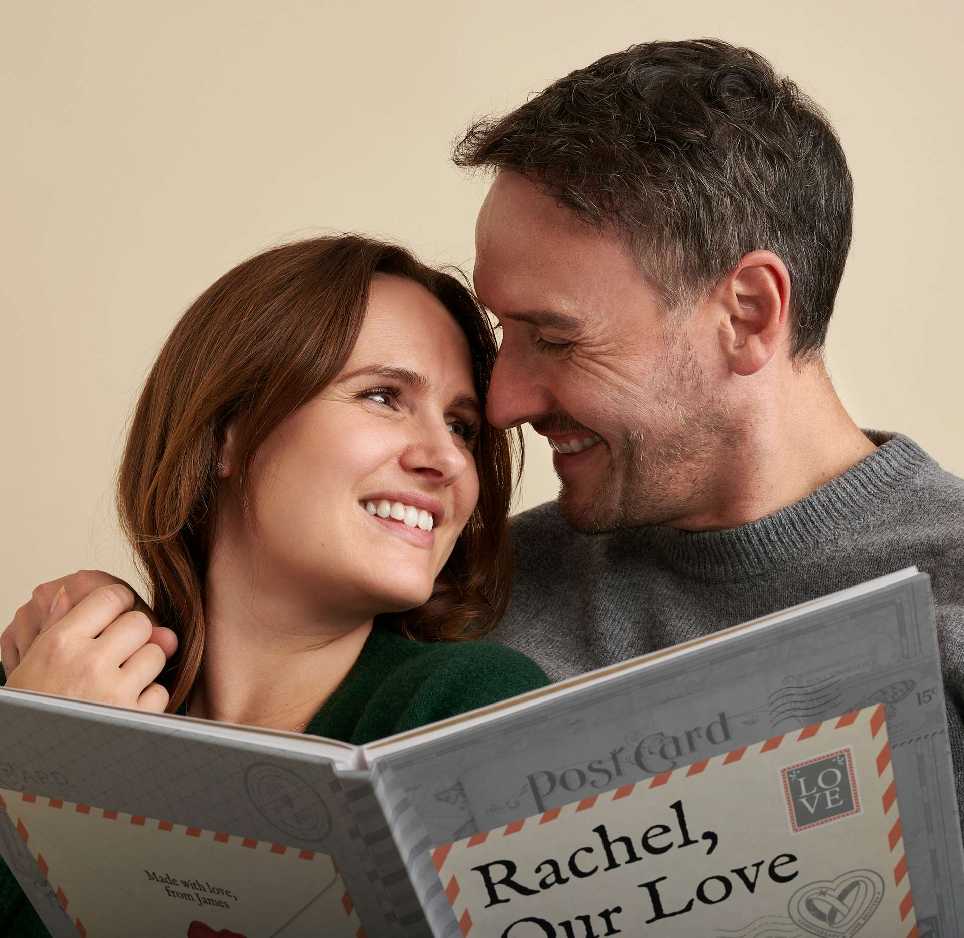 man and woman smiling reading our love story anniversary edition
