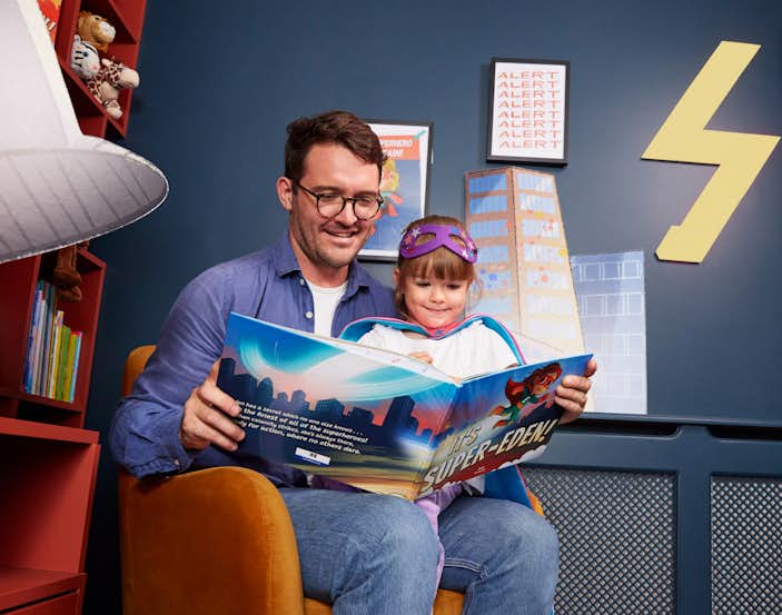 Father and her daughter reading the book