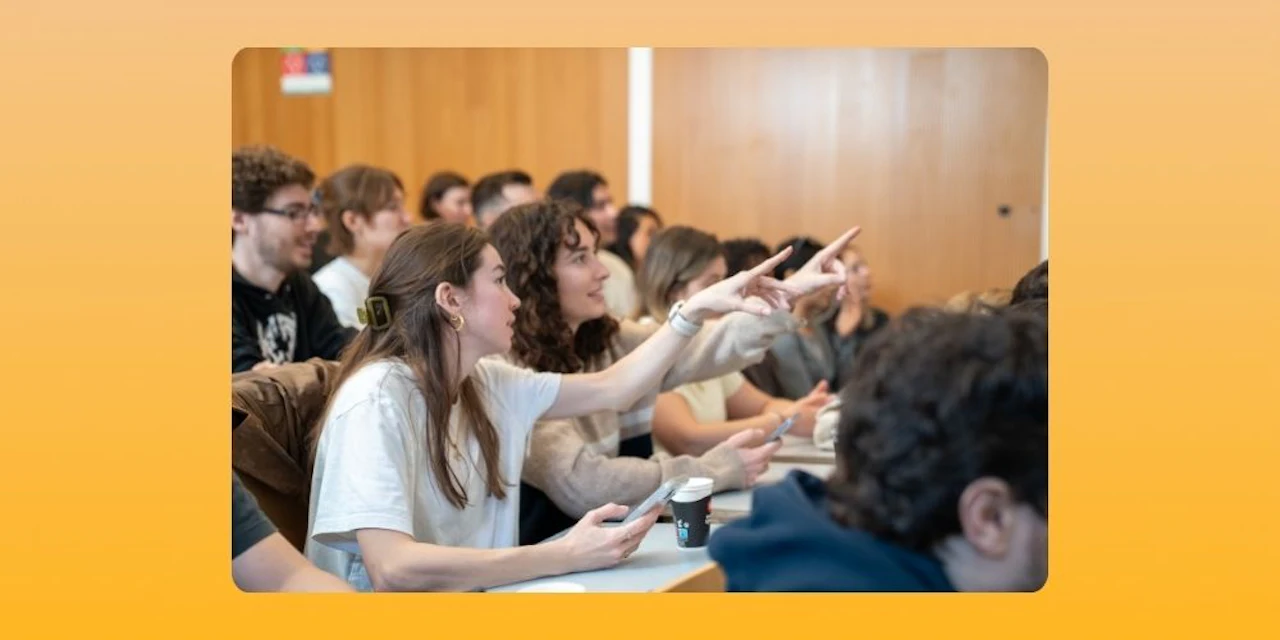 Students actively participating in a classroom, raising their hands and engaging during a lesson.