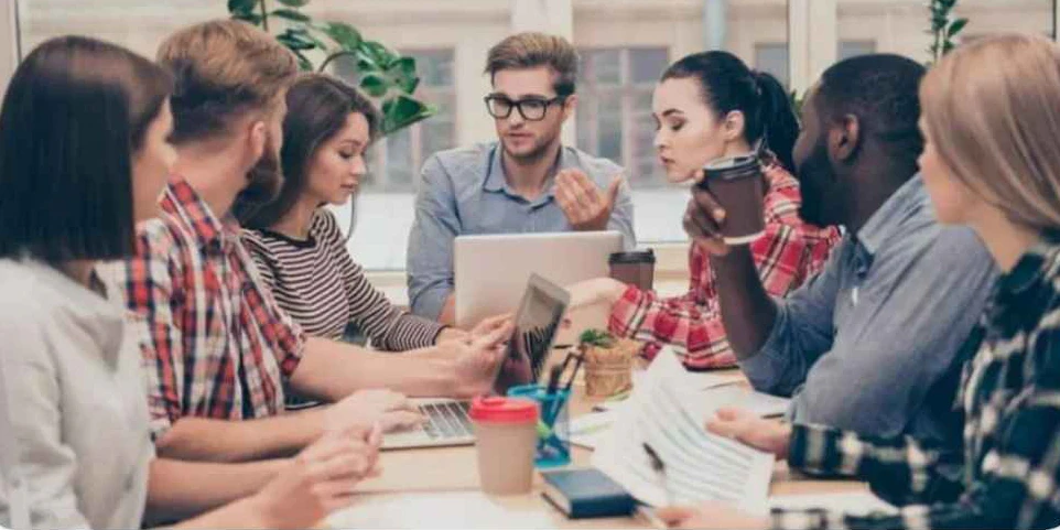 A group of people sitting at a table, discussing and brainstorming
