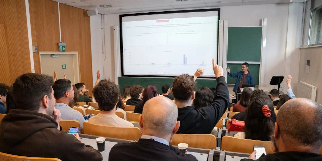 Students in class listening to lecture. A line is displayed and few students have raised their hands to ask their doubts.