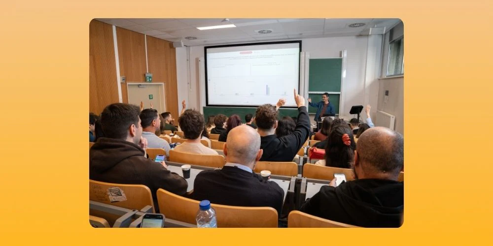 Students in class listening to lecture. A line is displayed and few students have raised their hands to ask their doubts.