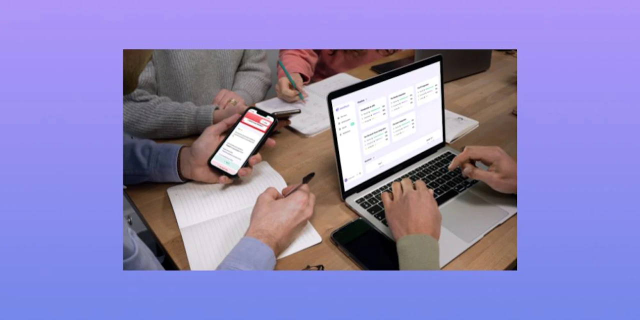 Des élèves étudient à un bureau en utilisant Wooflash sur leur téléphone et Wooclap sur leur ordinateur portable.