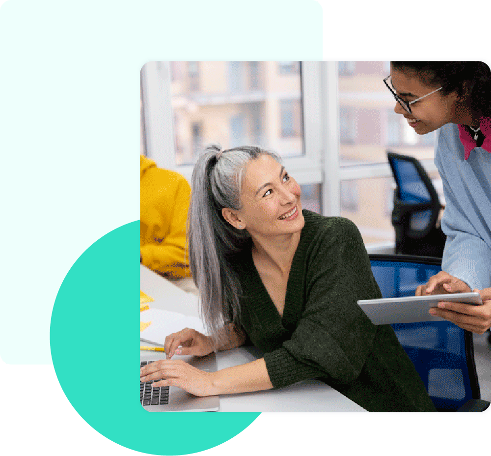 Teacher smiling while supporting a student with a tablet