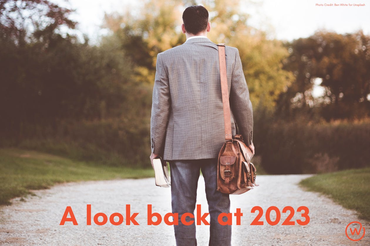 Image of a man in a suit looking down a dirt road.