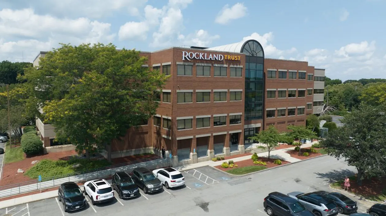 Photo of the building that Workspace occupies at 150 Grossman Drive in Braintree. It is a multi-story brick building.