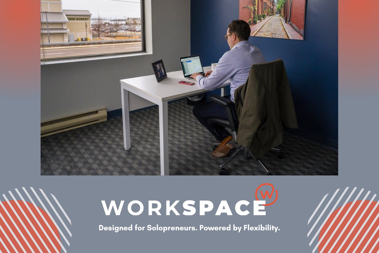 Workspace owner, Justin Moran, sitting at a desk working on a laptop.