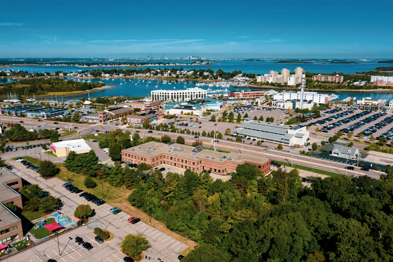 Aerial view of the Workspace@Shipyard building in Hingham, MA. The Hingham Shipyard and Hingham Bay are in the distance.