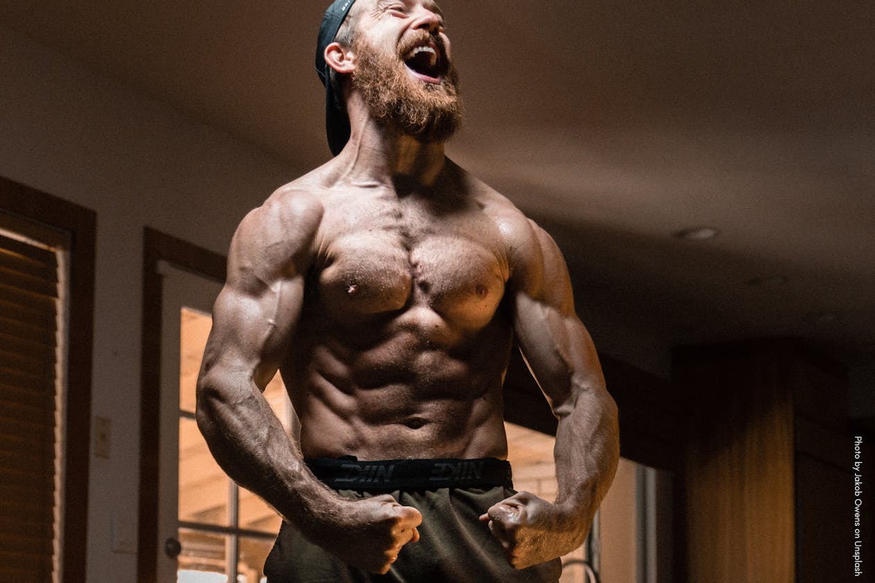 Man with beard flexing his muscles.