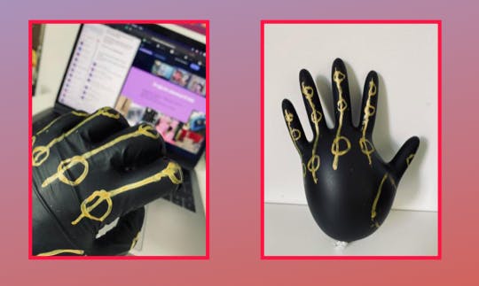 A black glove with gold markings all over it. One on a hand and one filled with air.