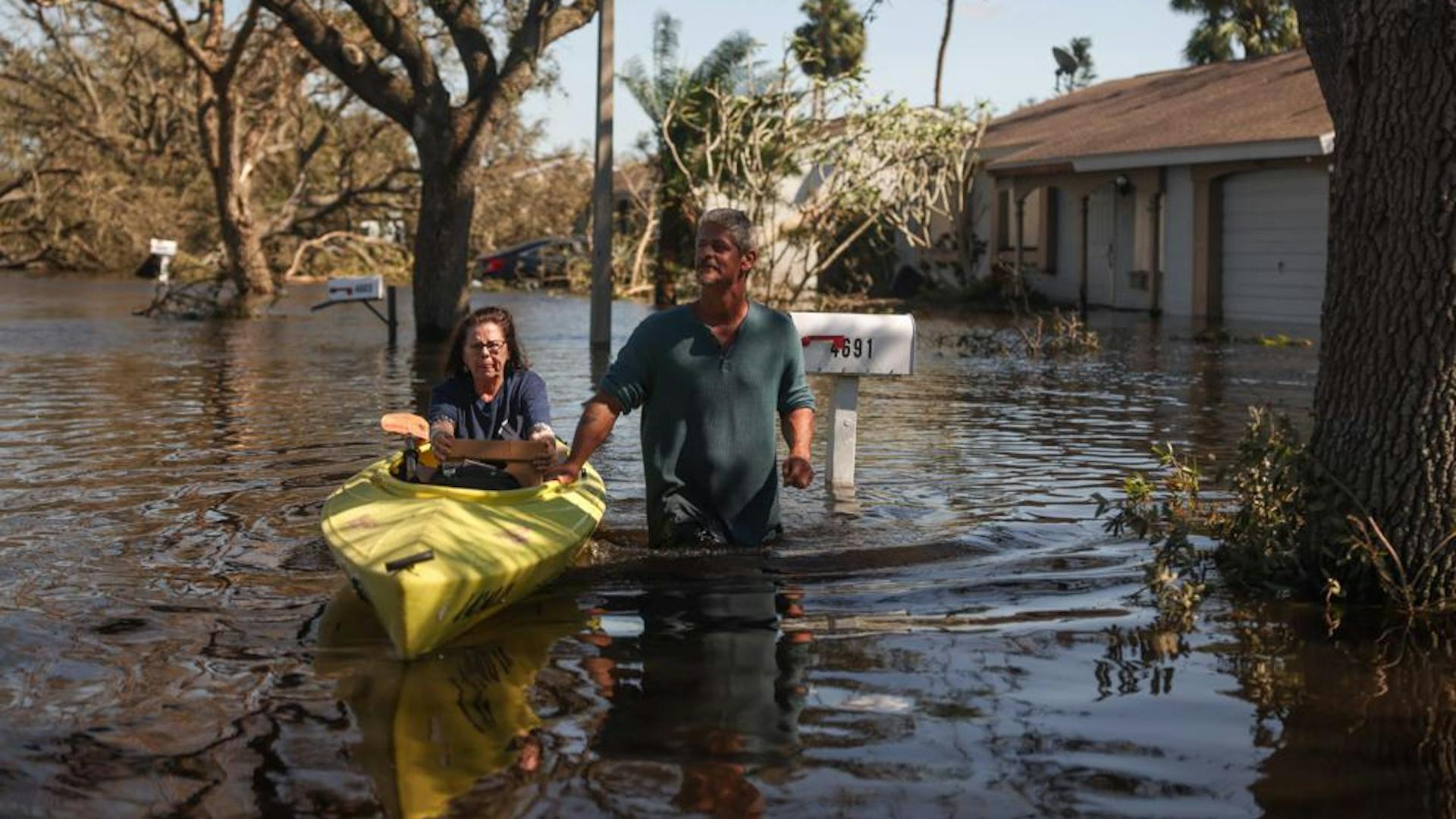 A couple in Florida stands in waist-deep water following Hurricane Ian.