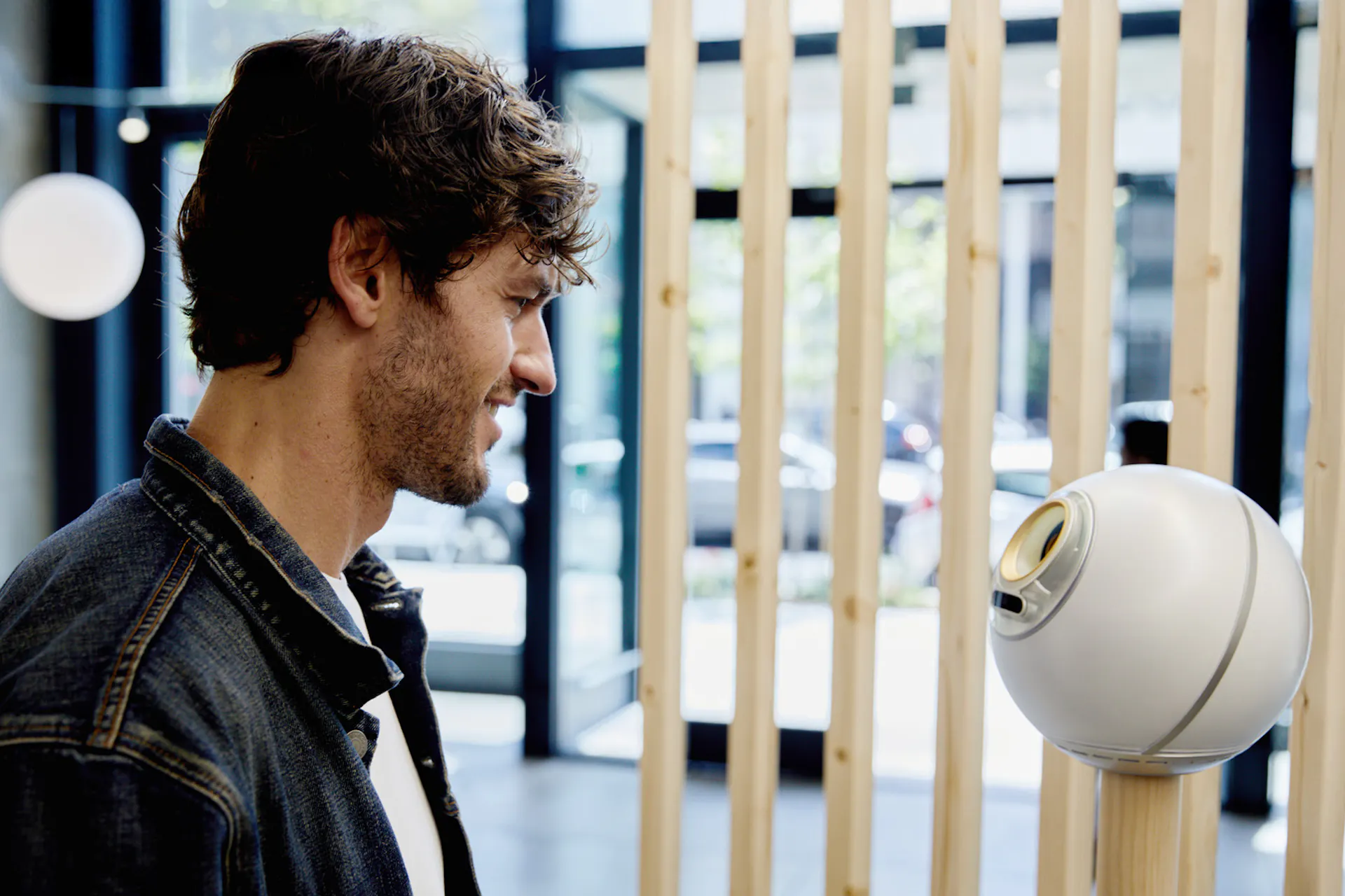 A man interacts with the Orb for verification in a retail space, showcasing community engagement and technology.