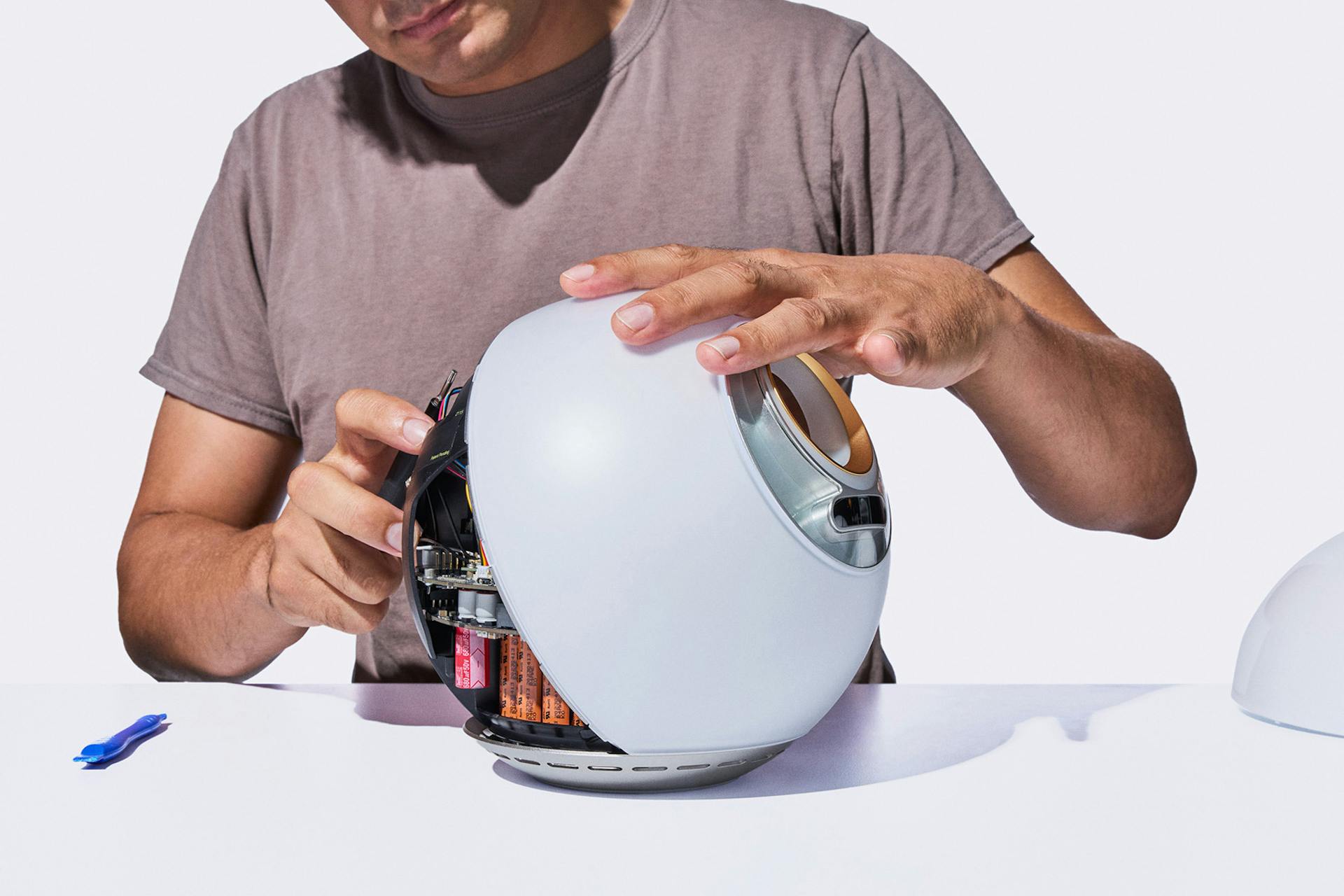 A person is assembling the Orb, focusing on its internal components, showcasing engagement with the technology.