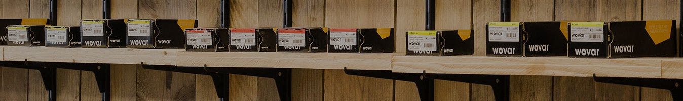 Row of boxes with the Wovar logo on a shelf.