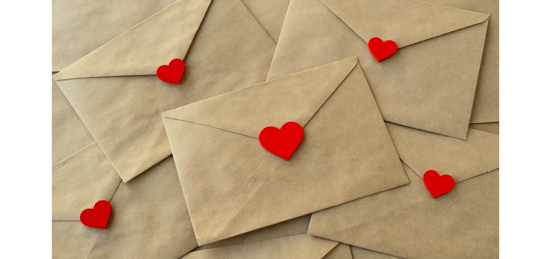 Pile of kraft envelopes sealed with red hearts, representing encouraging messages from family and friends for a big life transition