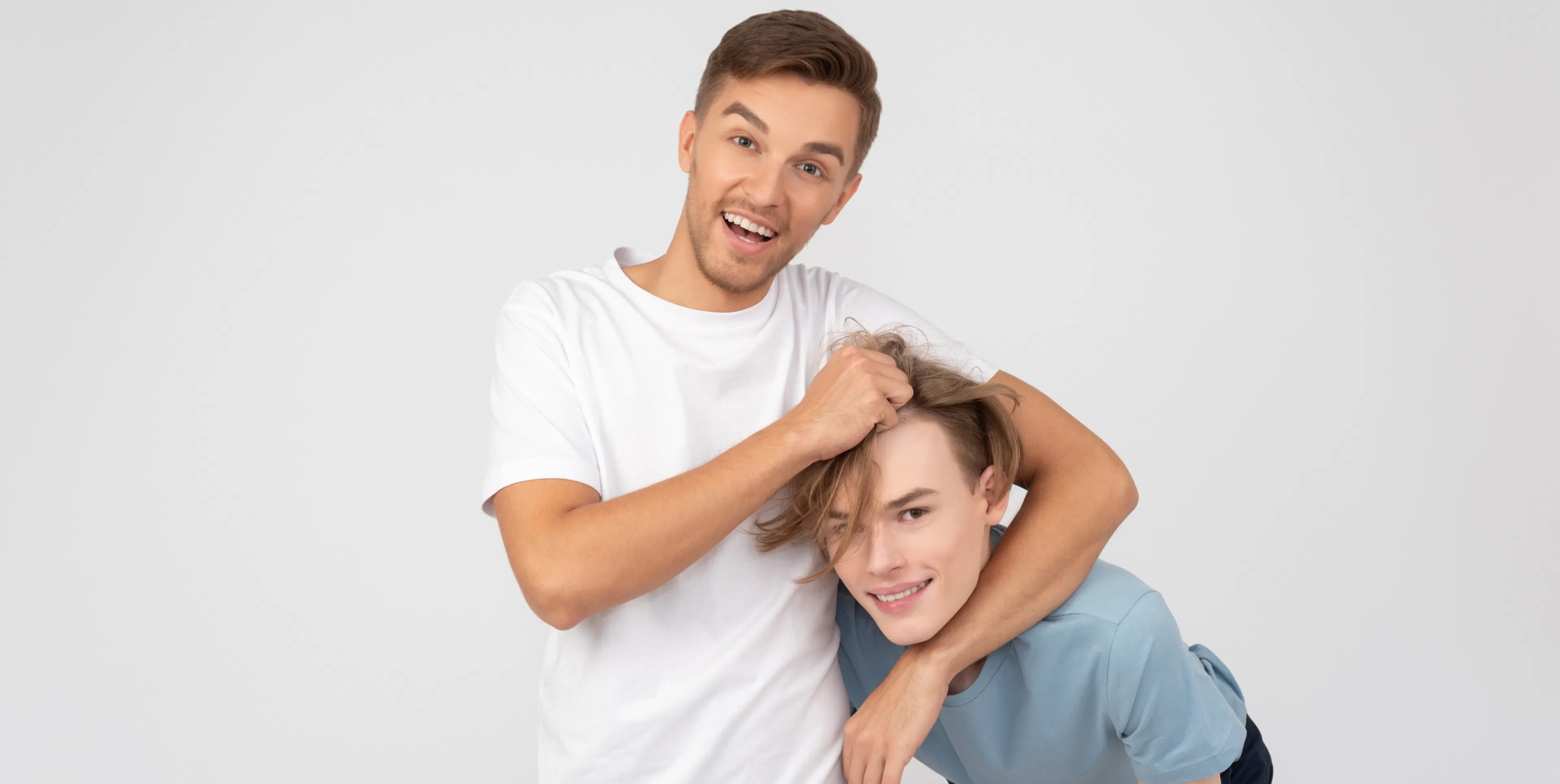 Man laughing while he jokes around with his younger sibling
