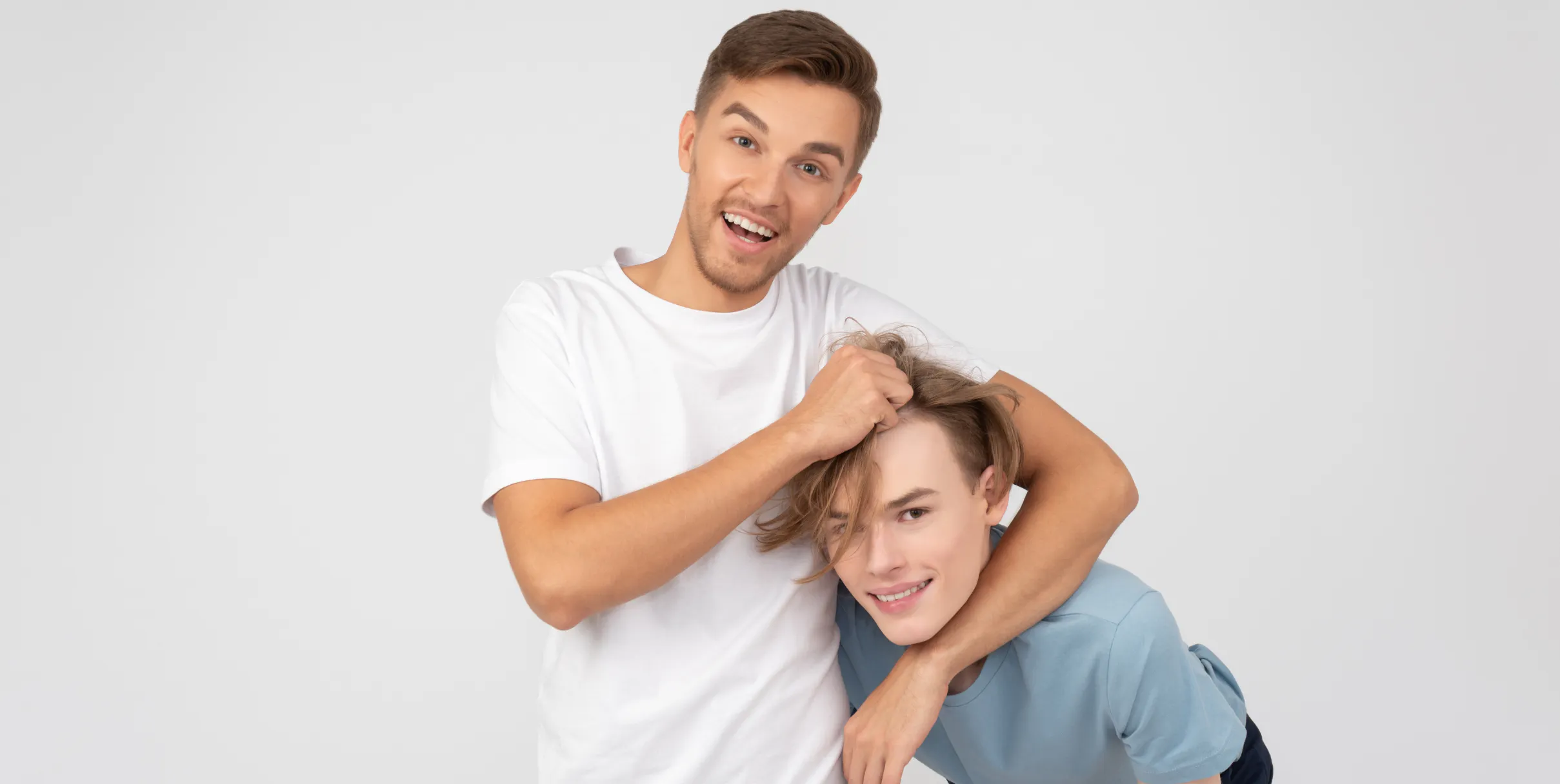 Man laughing while he jokes around with his younger sibling