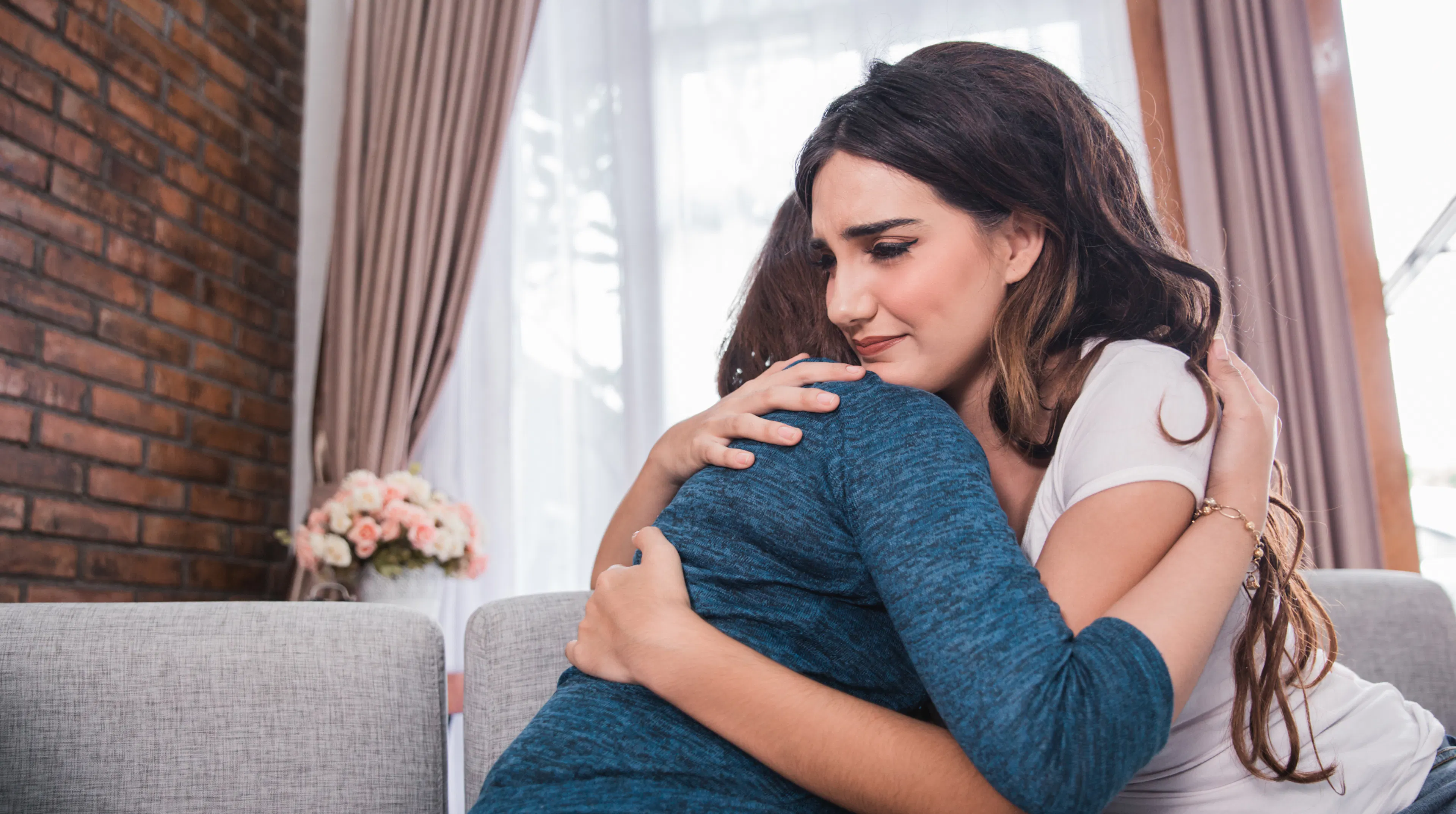 Friend offering comfort and support with a hug to someone who's struggling