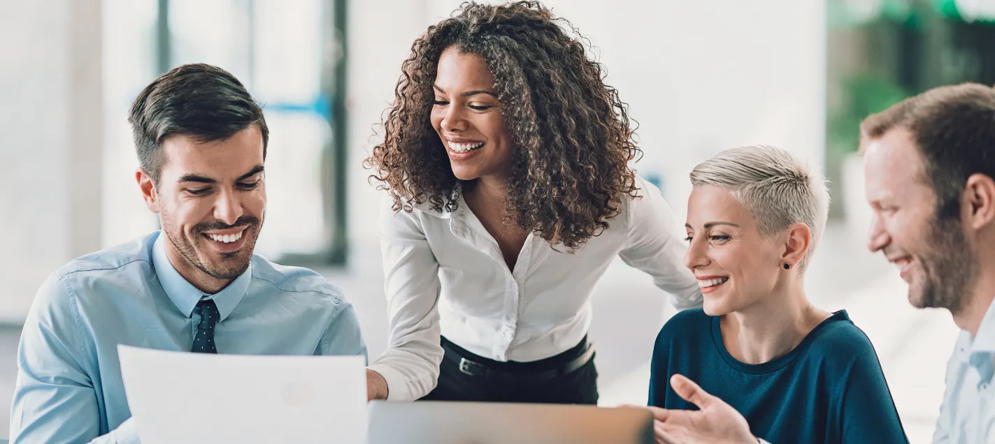 Employee smiling while she speaks with colleagues, representing how good it feels to work somewhere that notices you