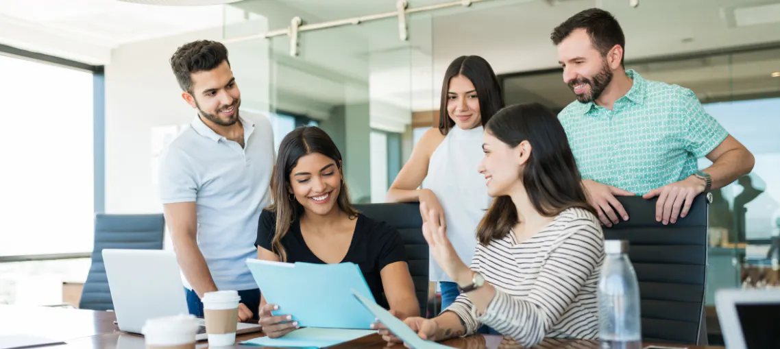 Colleagues smiling while they worth together, representing good workplace culture built by executive assistants and administrative professionals