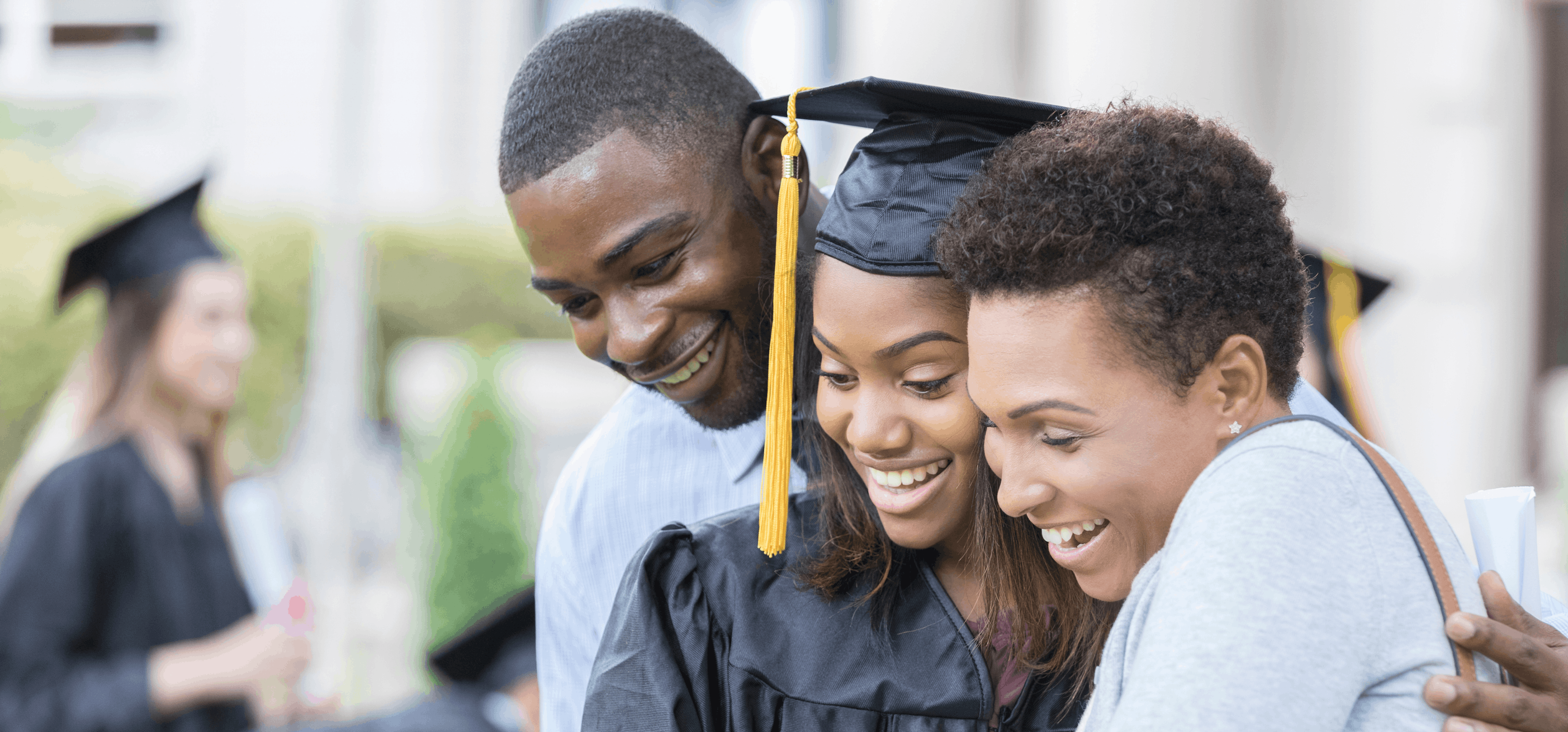 Graduate with parents smiling as they look at their Woxbox gift