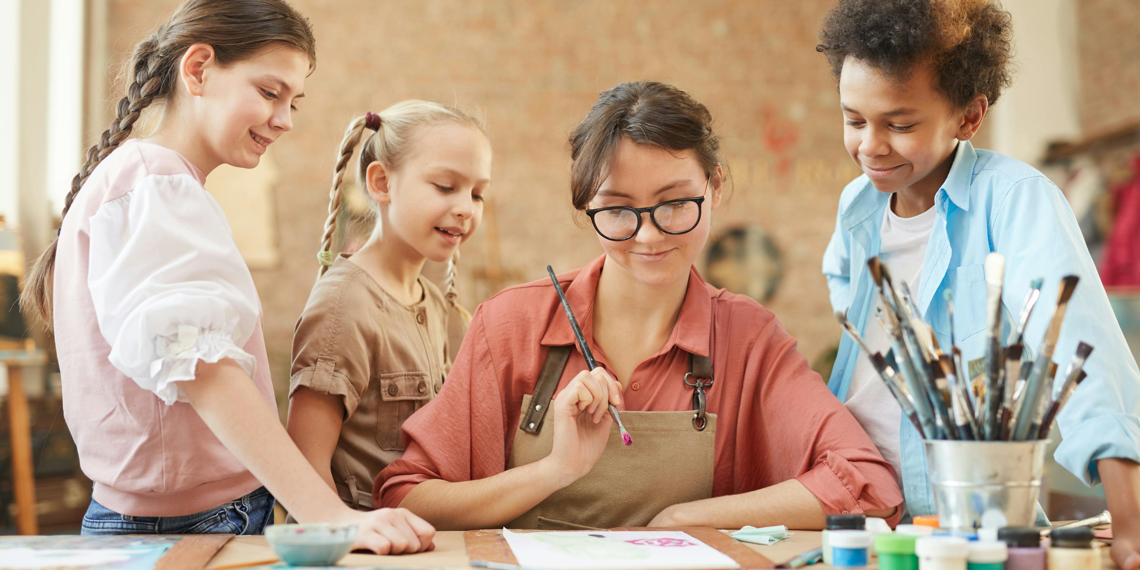 Volunteer painting with kids, by Woxbox Gift