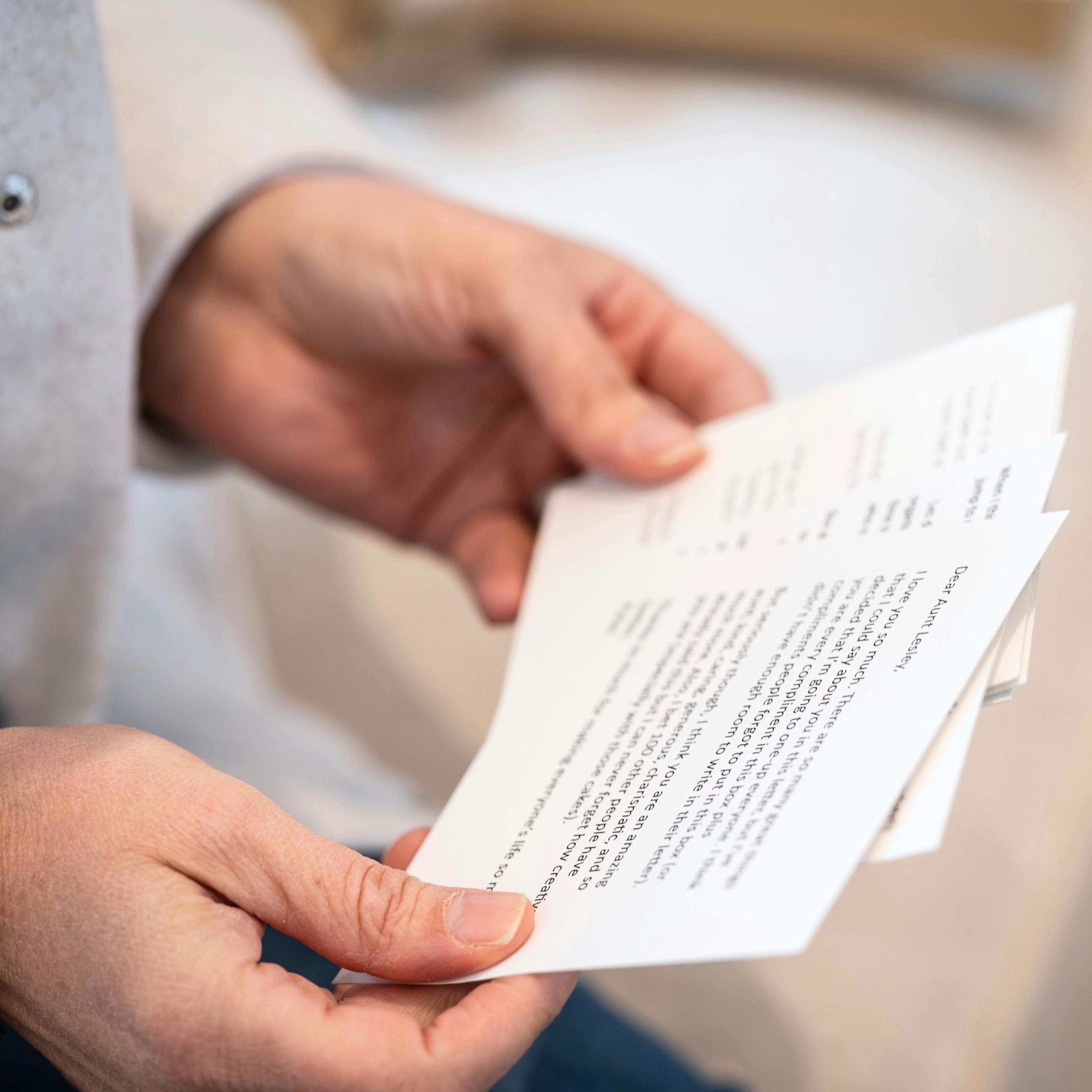 Person reading their Woxbox memorial sympathy message cards at funeral, by Woxbox Gift