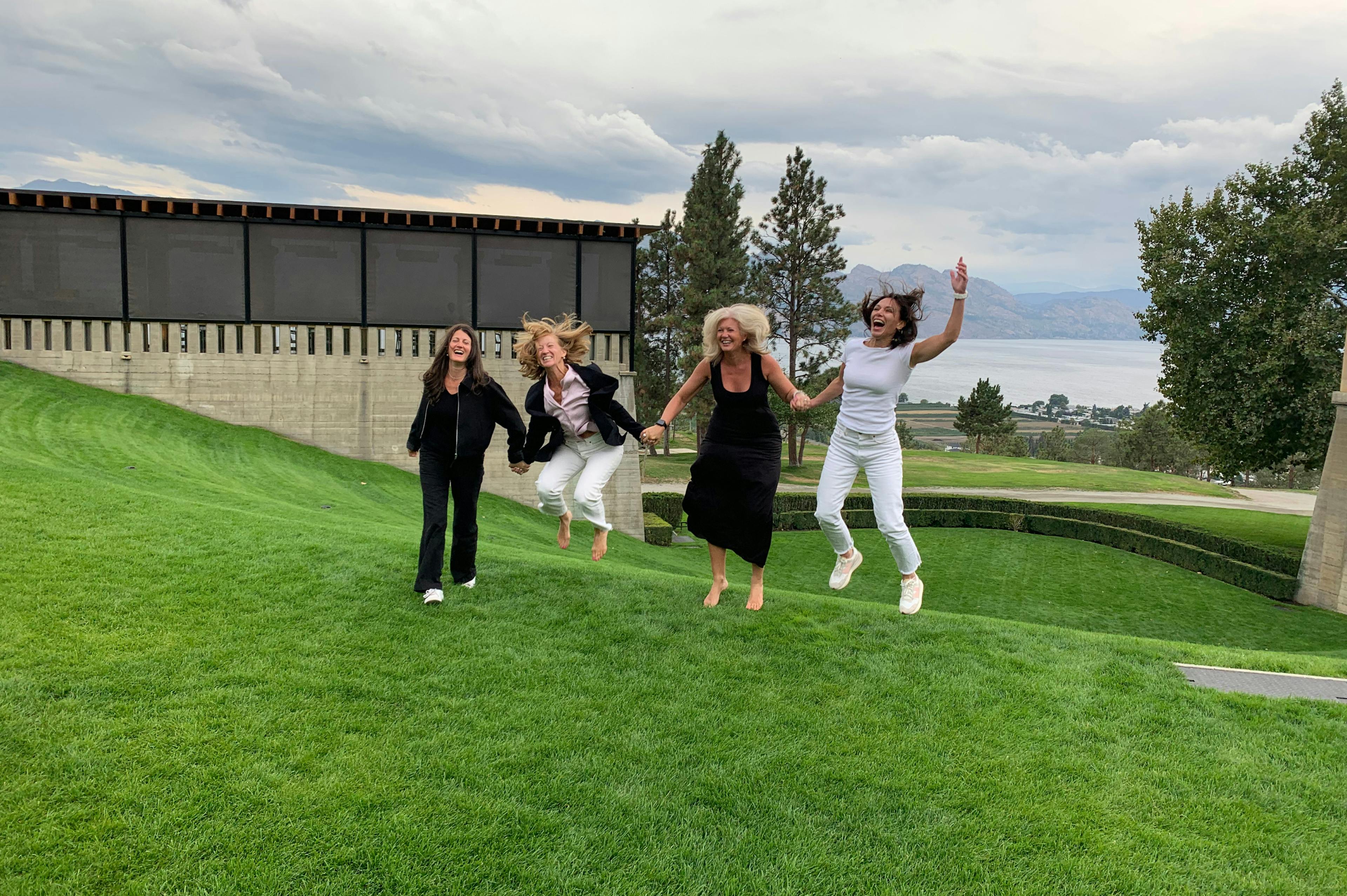 4 Friends Jumping, laughing and having fun outside at Mission Hill Winery in BC