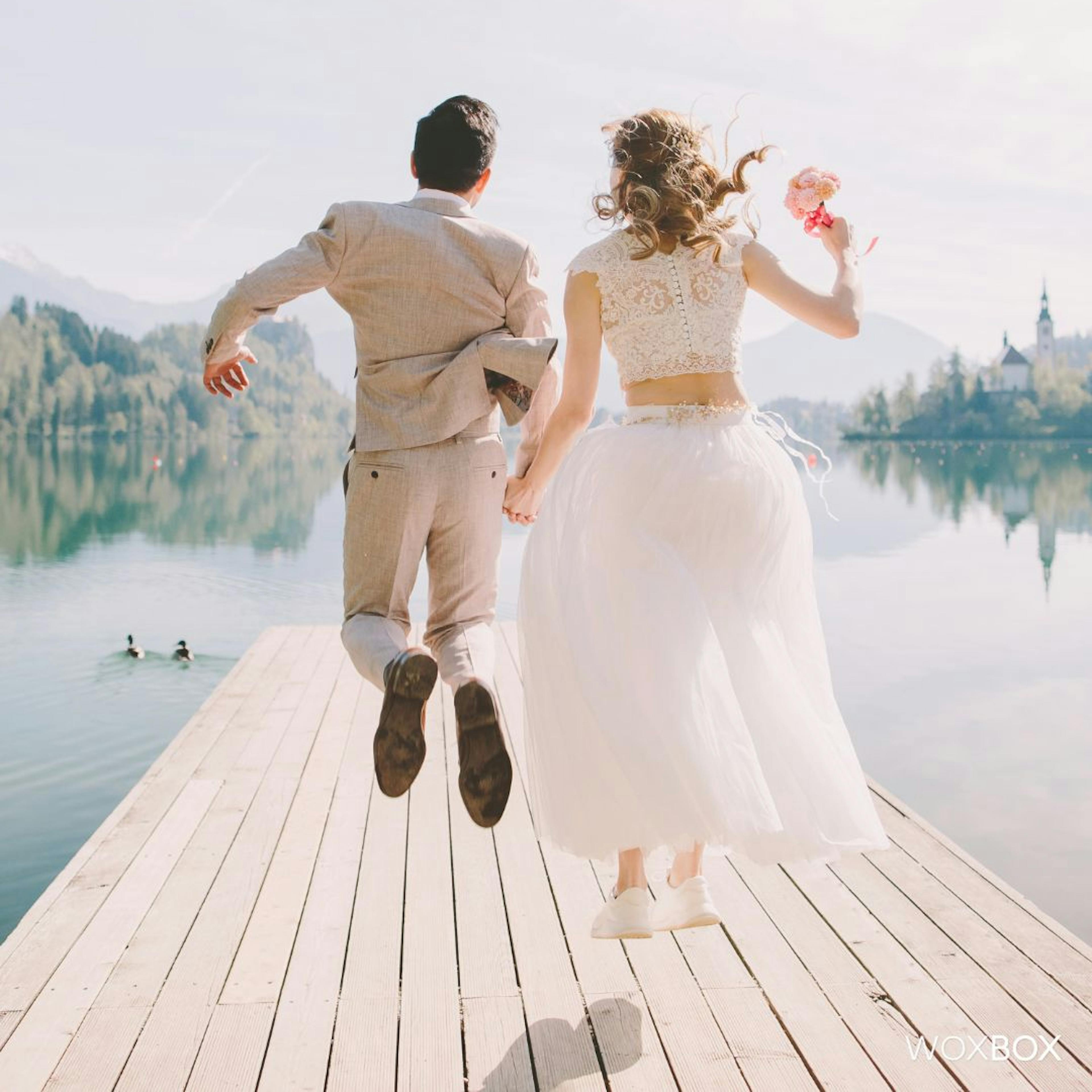 Bride and Groom jumping in the lake on their summer wedding day