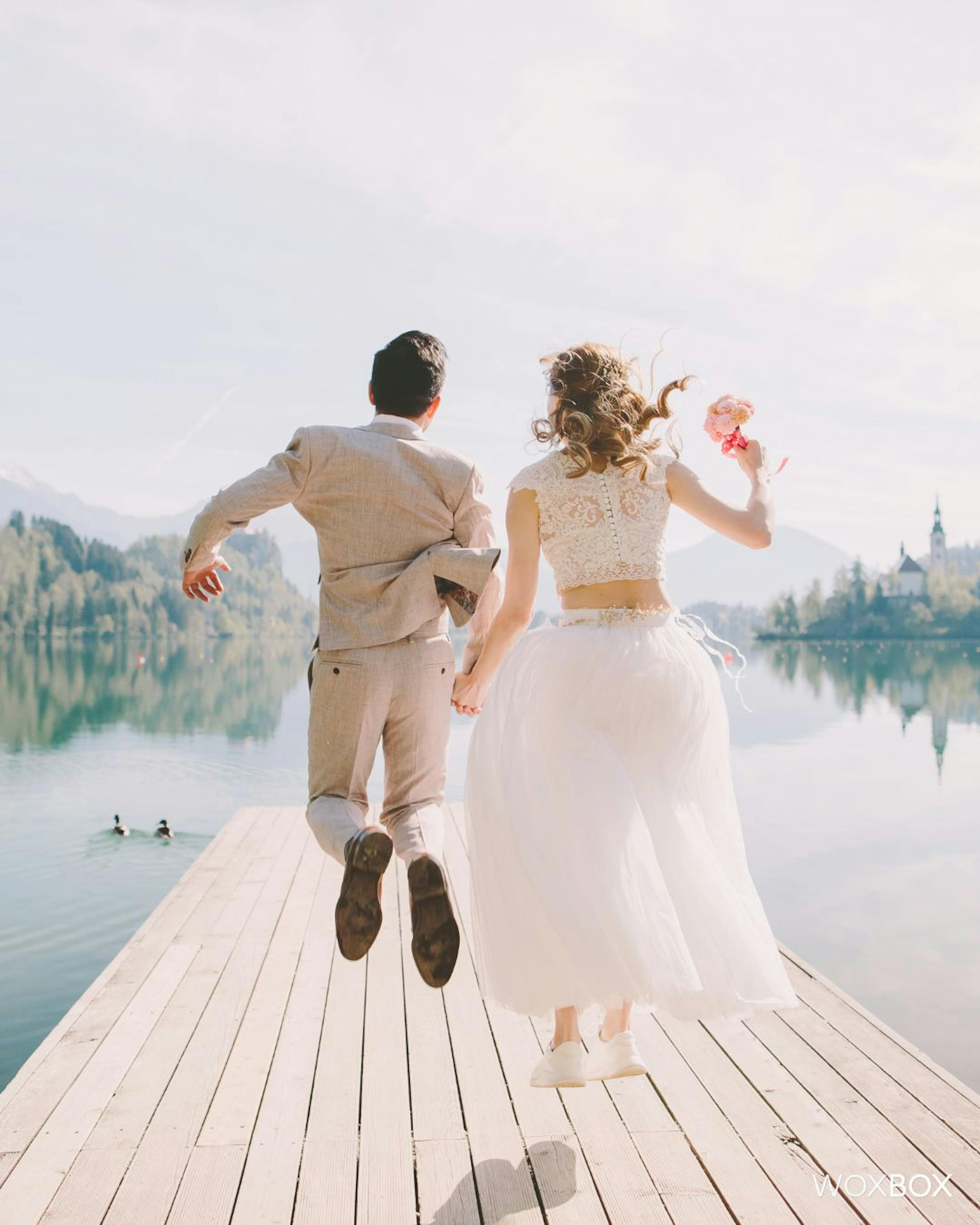 Bride and Groom jumping in the lake on their summer wedding day