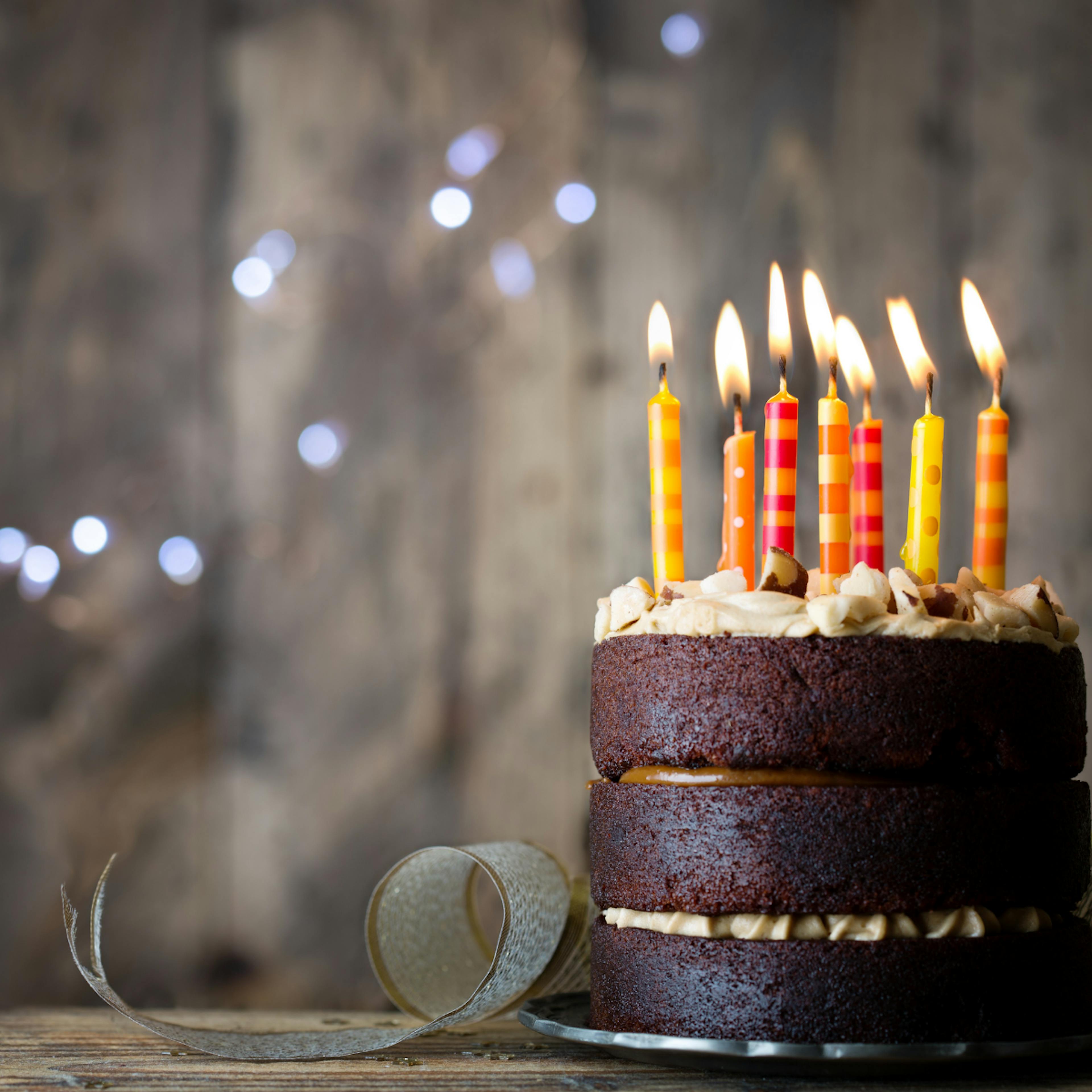Chocolate Cake with colourful lit birthday Candles 