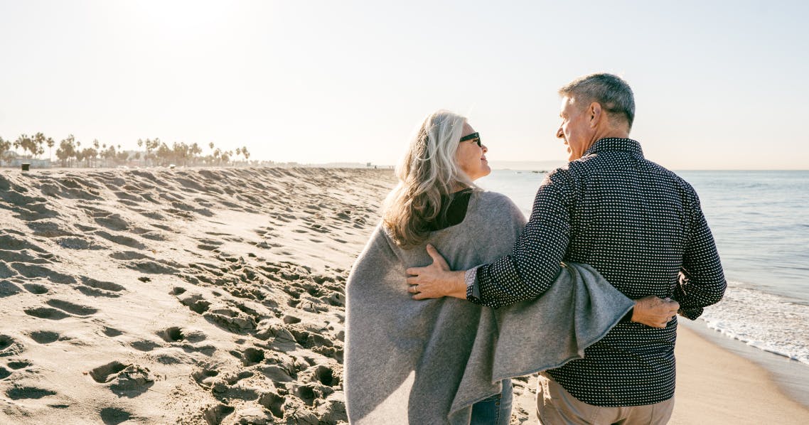 Retired couple walking on the beach