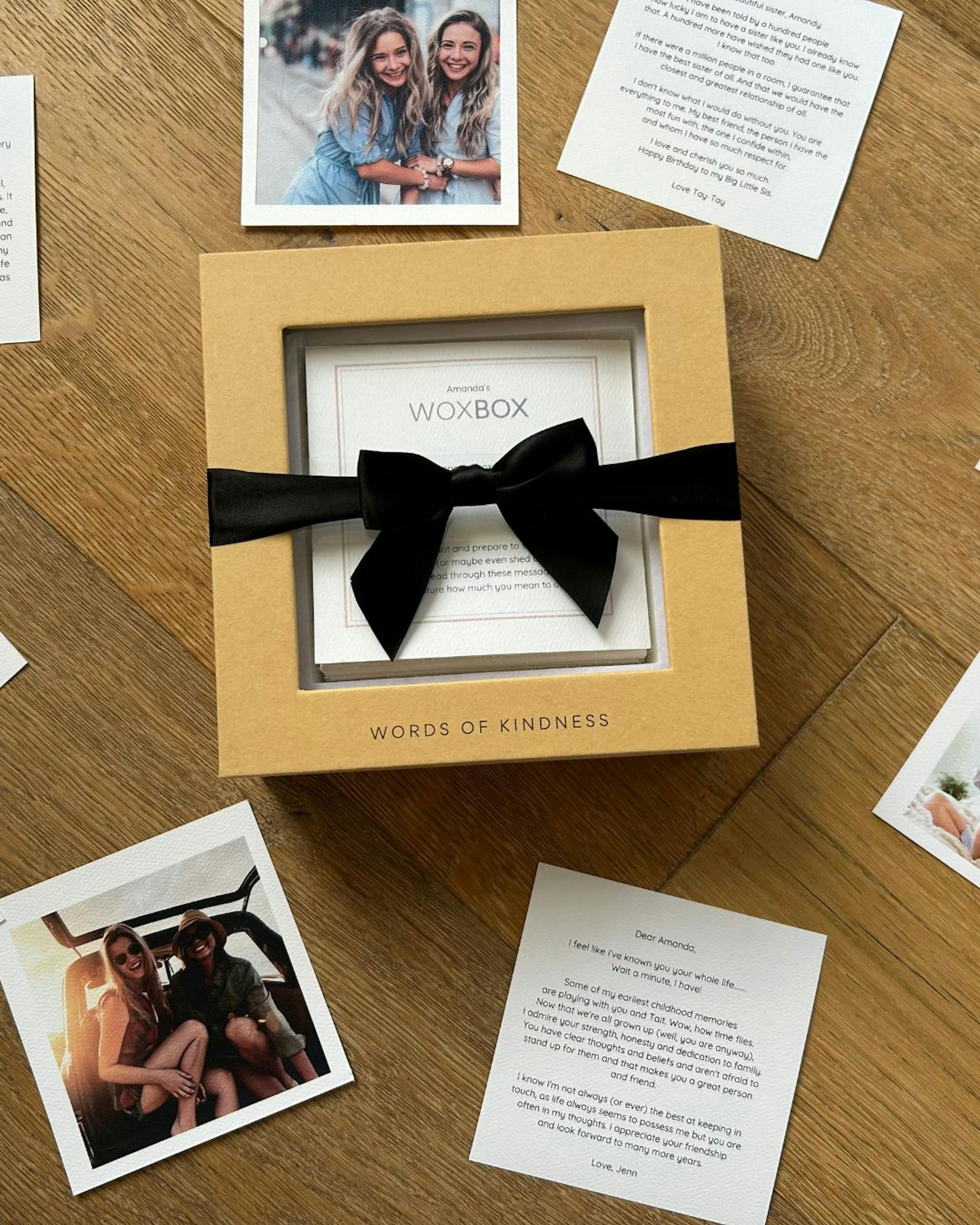Woxbox with black ribbon on table with words of kindness messages