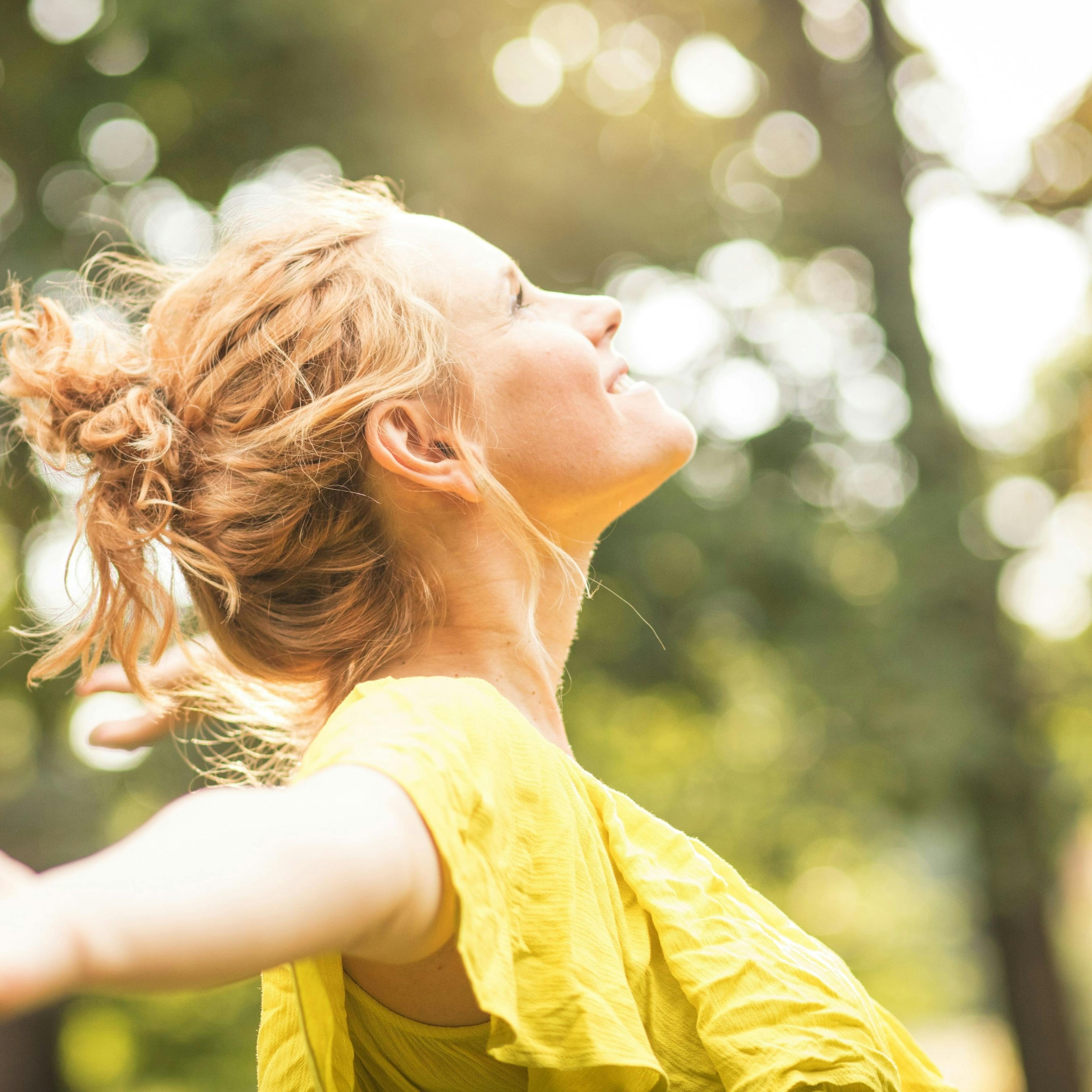 Woman smiling and finding joy with the sun on her face