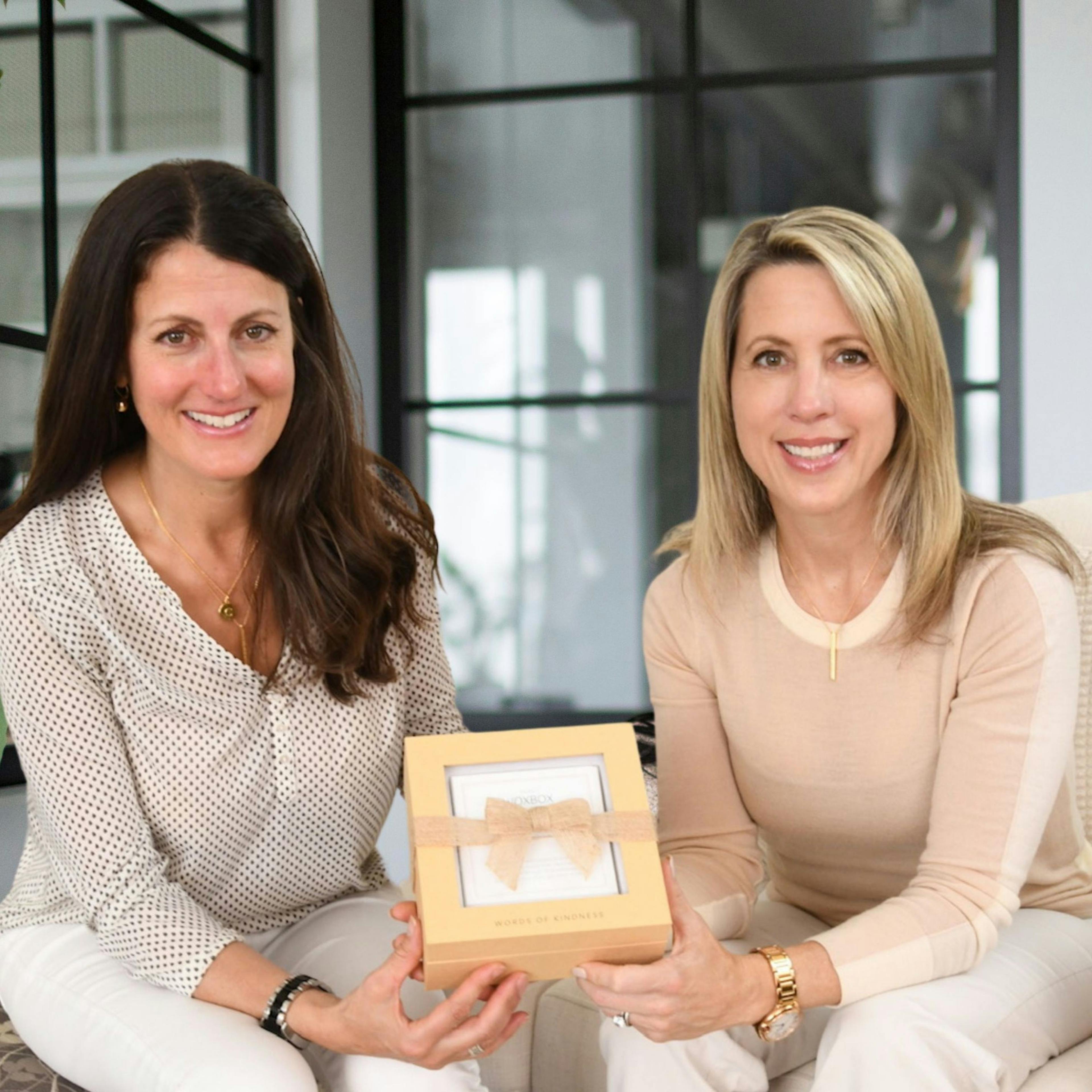 Cindy Iatan and Carey Kirchmair, co-founders of Woxbox, holding a Woxbox Words of Kindness Gift