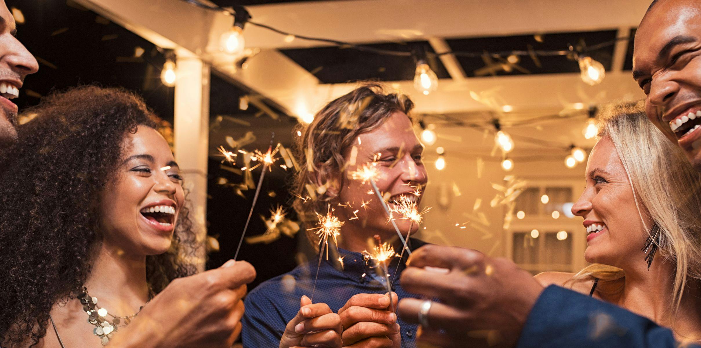Close friends gathering to reflect on new year's eve and celebrate their relationship with sparklers