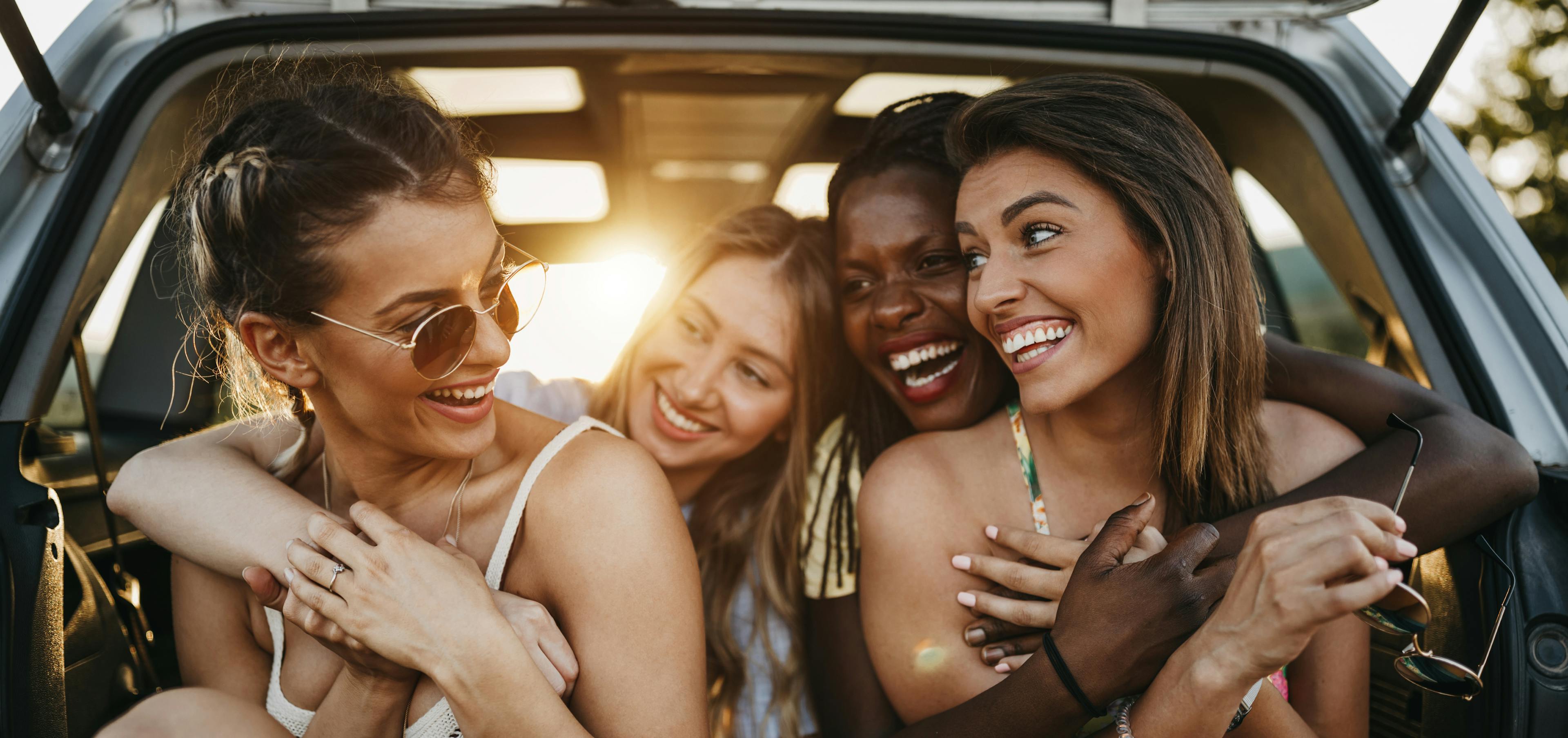 Group of women friends laughing together on their Galentine's Day road trip 