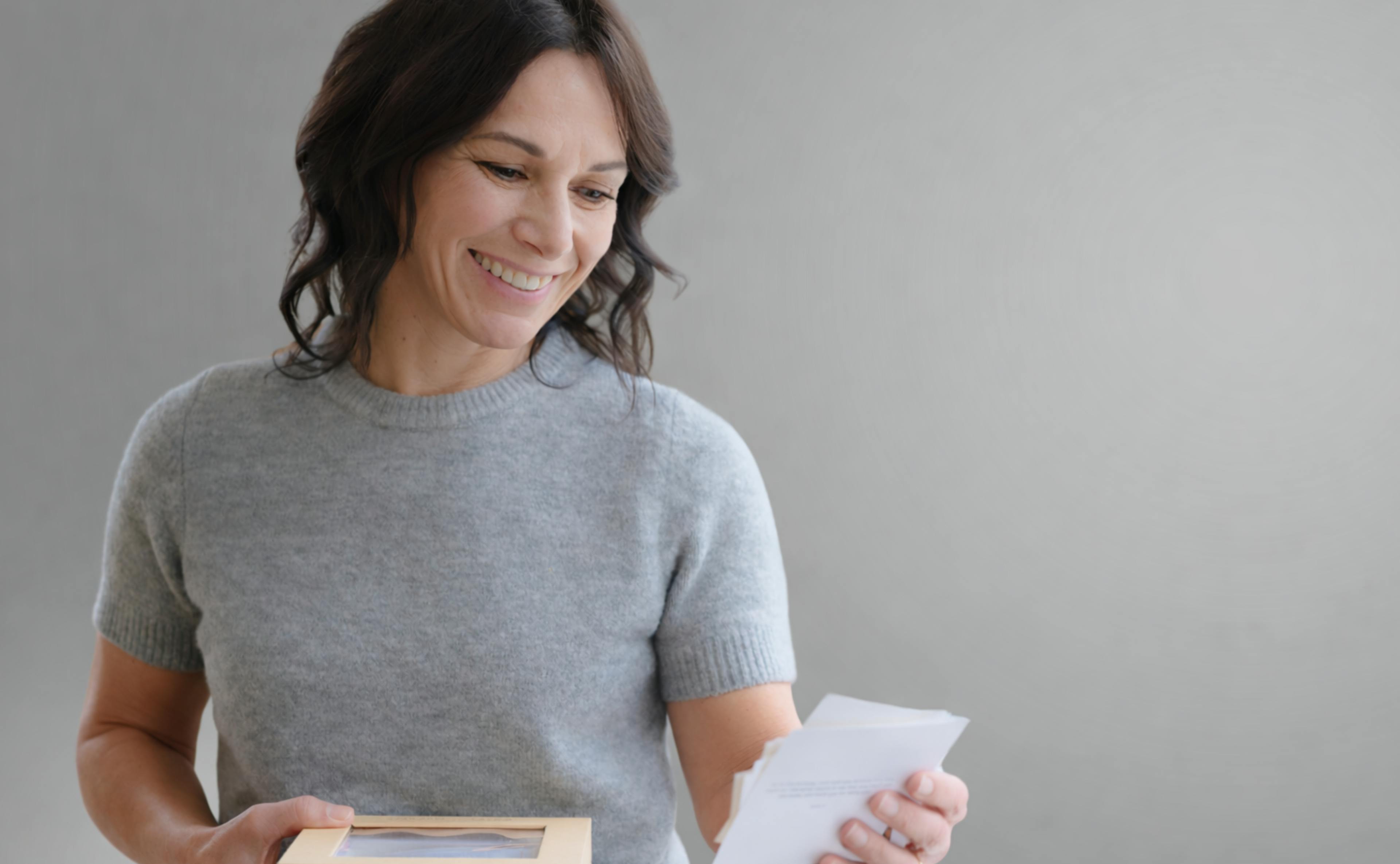 Woman reading emotional message and smiling with tears of joy