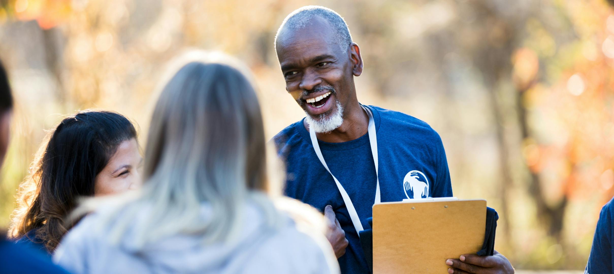 Volunteer coach smiling with his team, representing an unsung hero receiving recognition