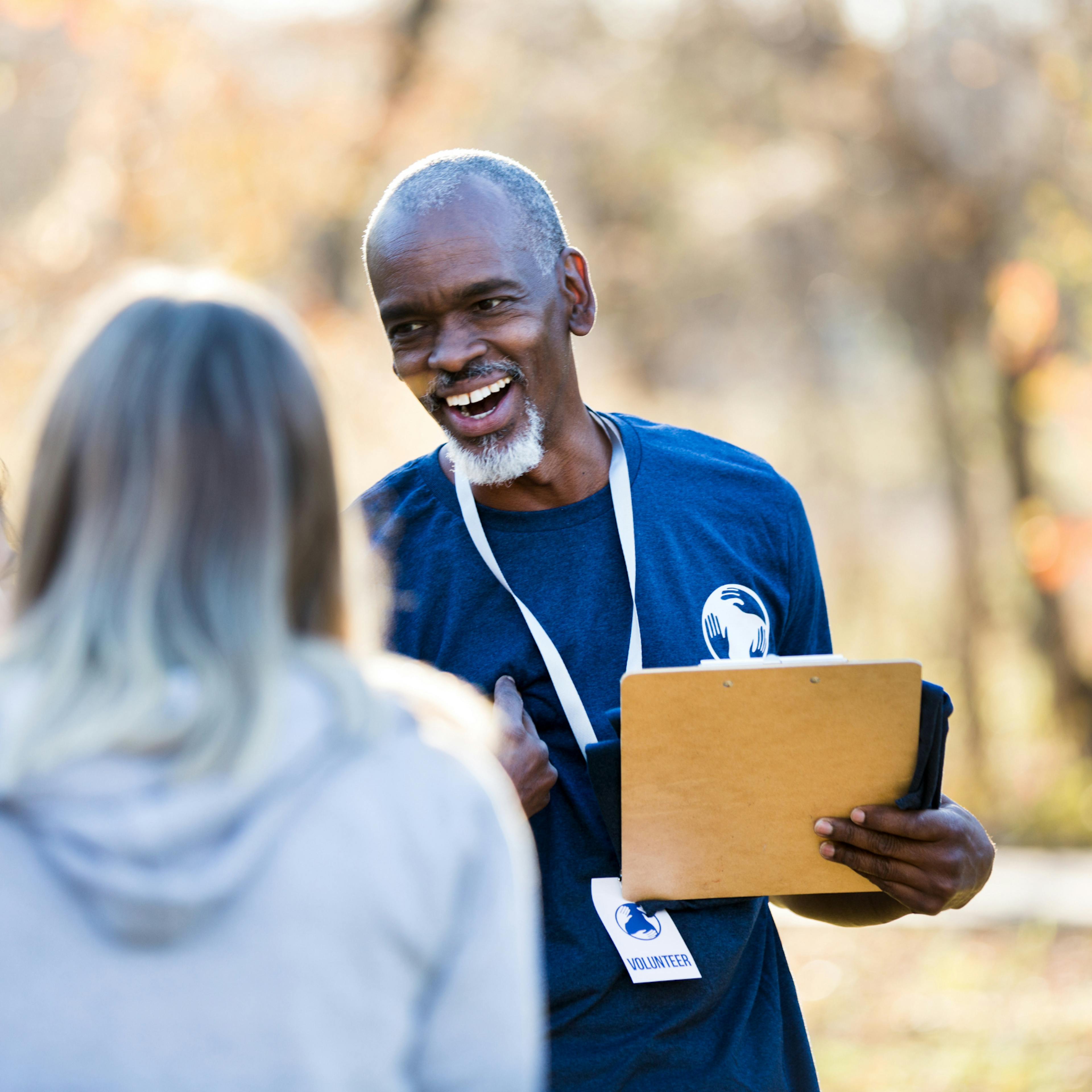 Volunteer coach smiling with his team, representing an unsung hero receiving recognition