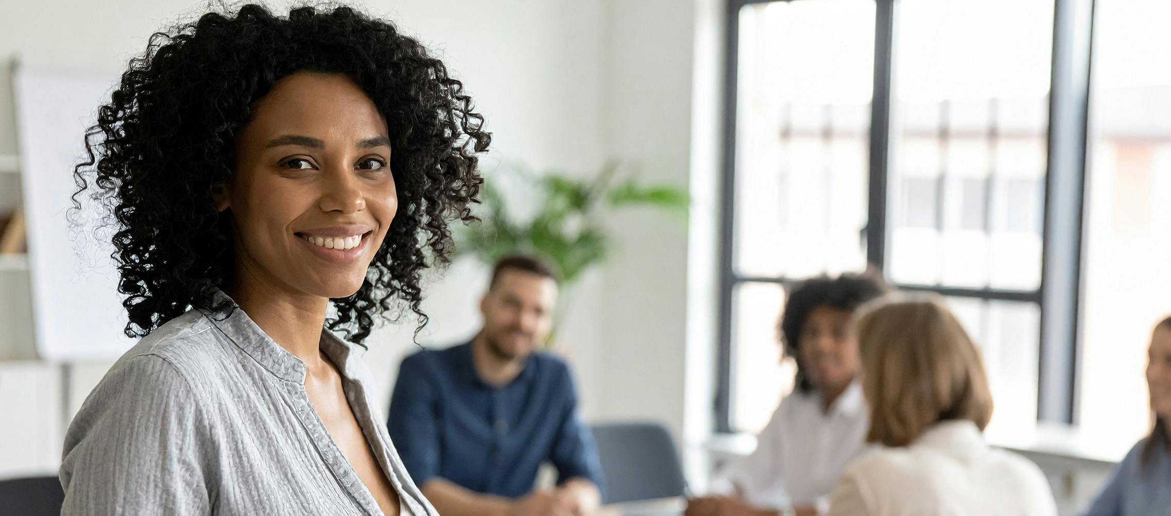 Employee smiling during a meeting at work where she is about to receive a farewell gift