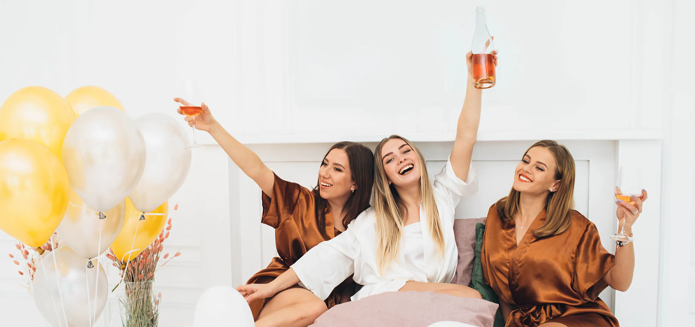 Best friends celebrating an engagement announcement, clinking champagne glasses and smiling