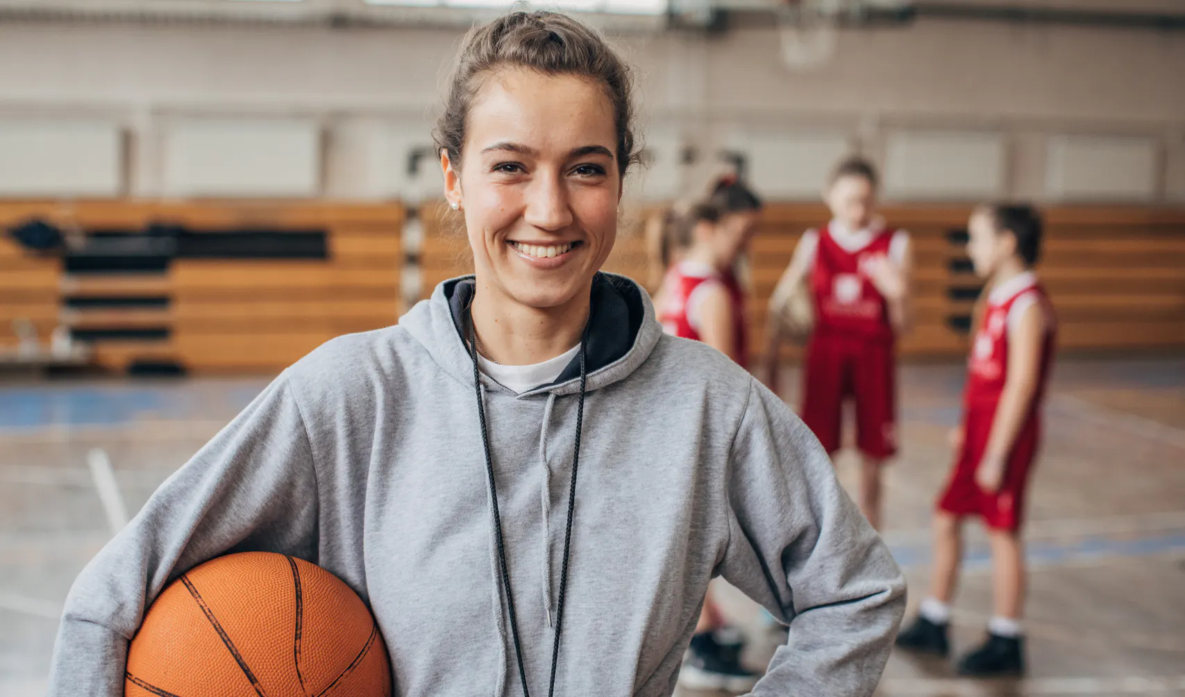 Volunteer coach smiling with their team, representing an unsung hero
